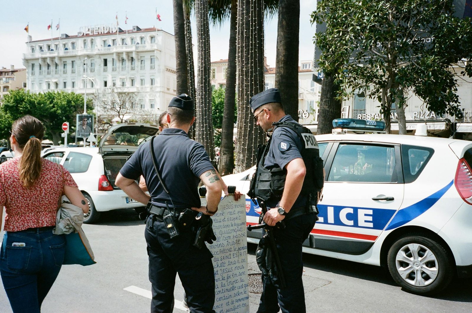Police officers standing near a vehicle on the road